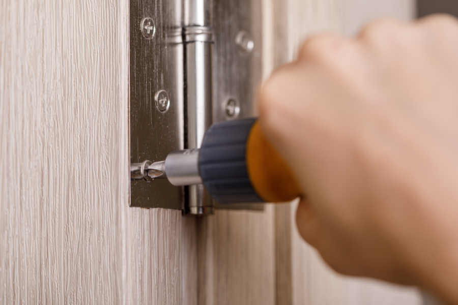 how-many-hinges-does-a-fire-door-need-featured-image hinges being installed on a fire door